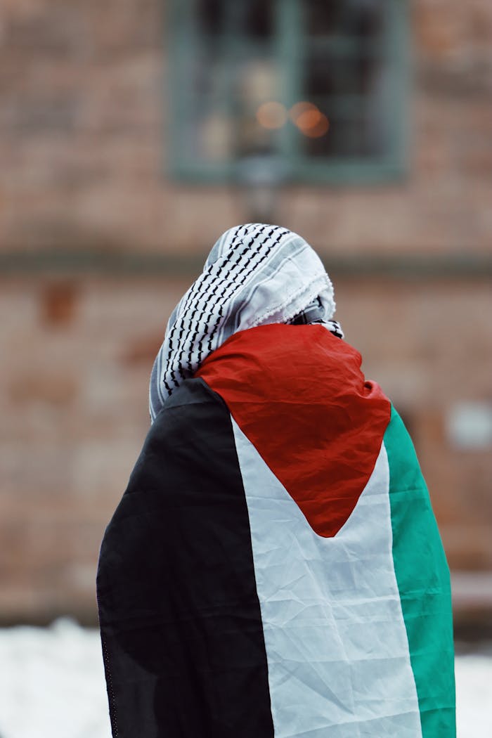 An adult protester wrapped in the Palestinian flag during a peaceful protest in Jönköping, Sweden.